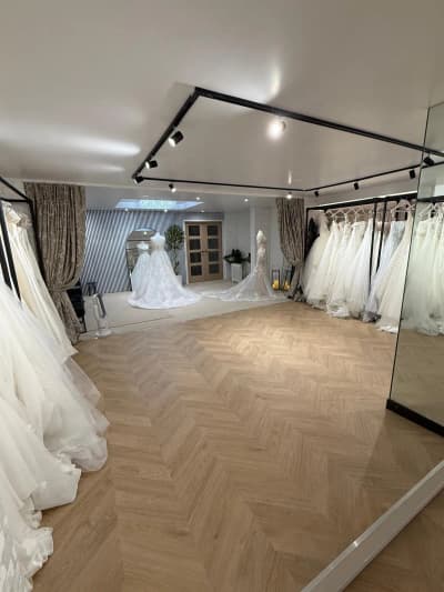 An arched mirror reflecting wedding gowns in natural light